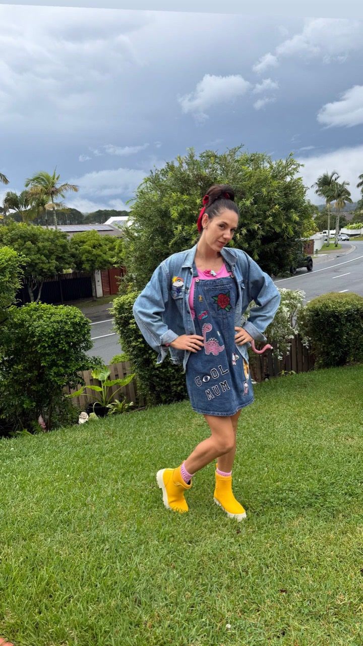 Kymmy, owner of Kymmy & Co., wearing a decorated denim outfit and yellow boots outdoors.